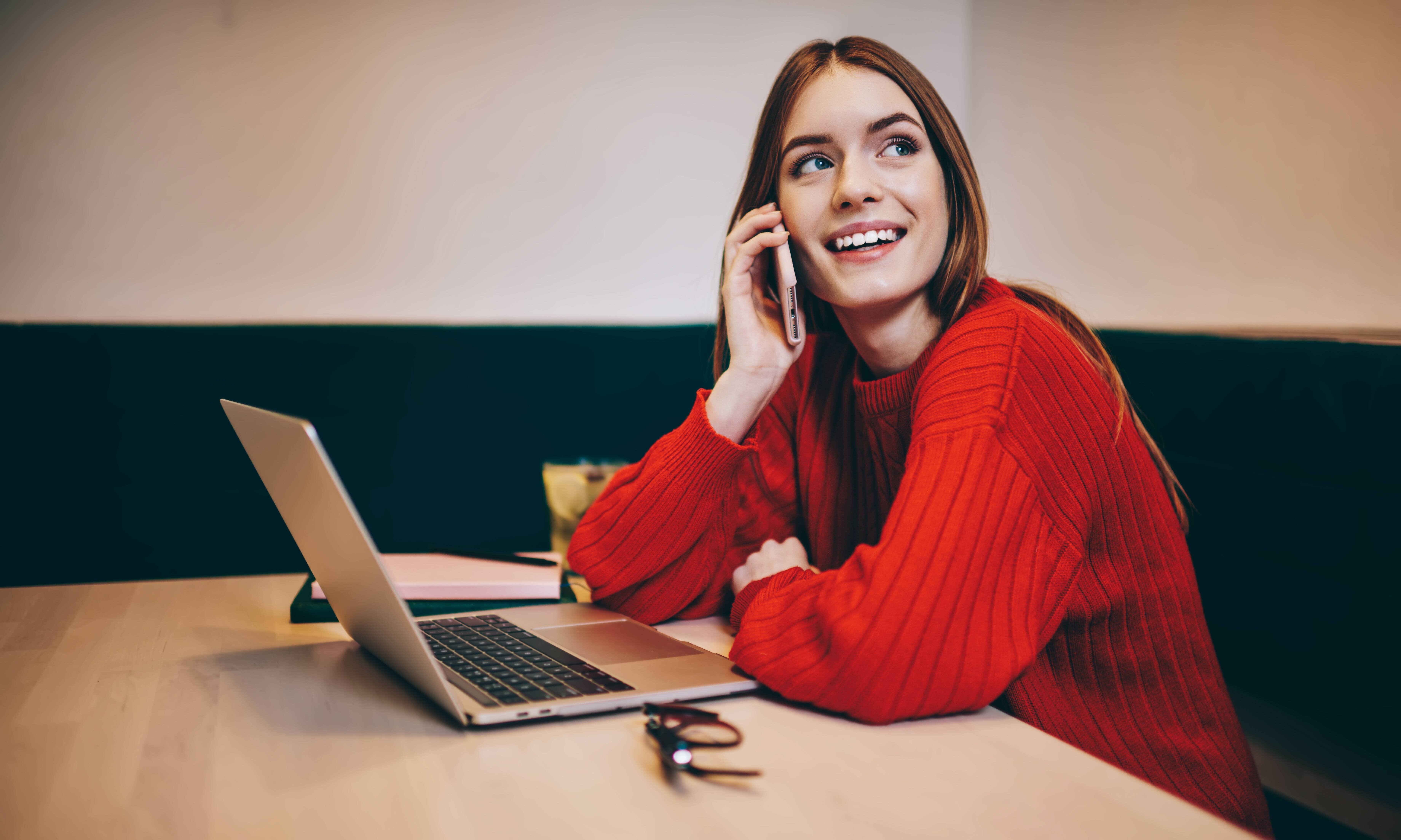 positive-freelancer-speaking-on-smartphone-while-w-2023-09-01-21-21-54-utc